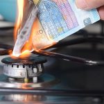Gas price increase concept: 20 euro banknote burnt on a lit stov