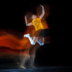 Young female volleyball player isolated on black studio background. Woman in sport’s equipment training and practicing.